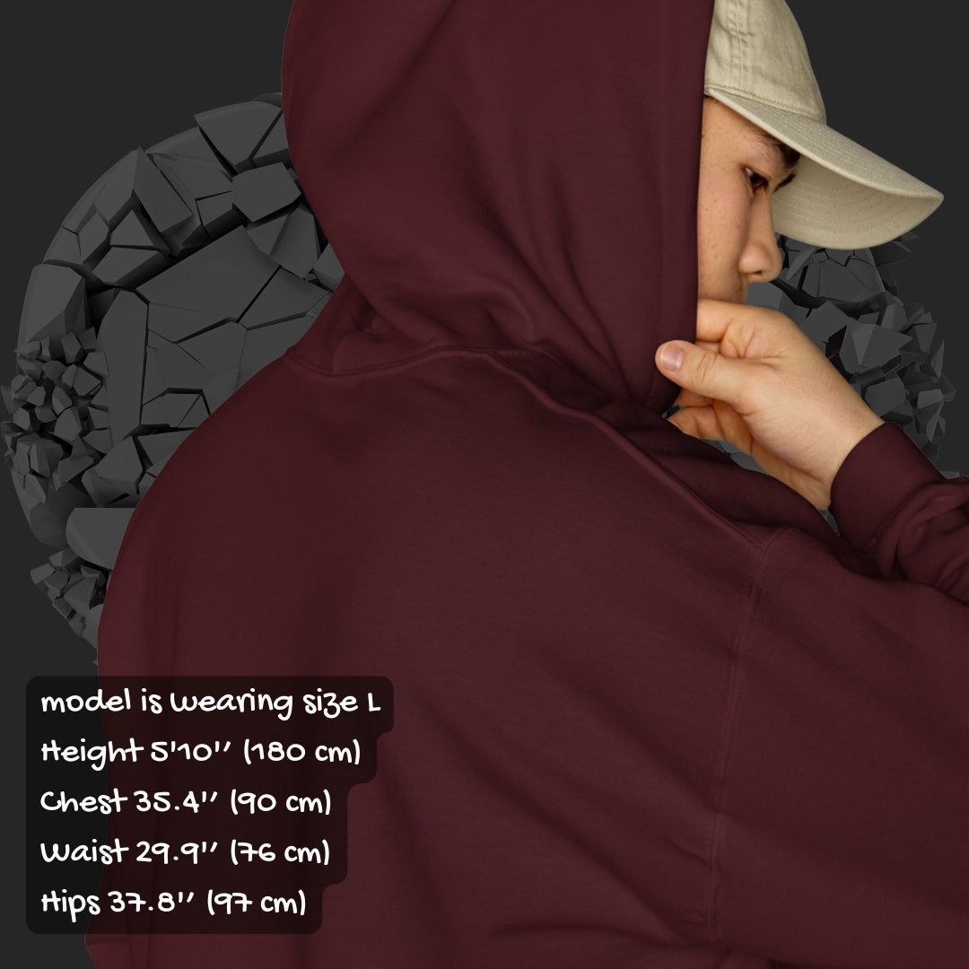Person wearing a brown  hoodie with a pink checkered and distressed heart design against a dark background