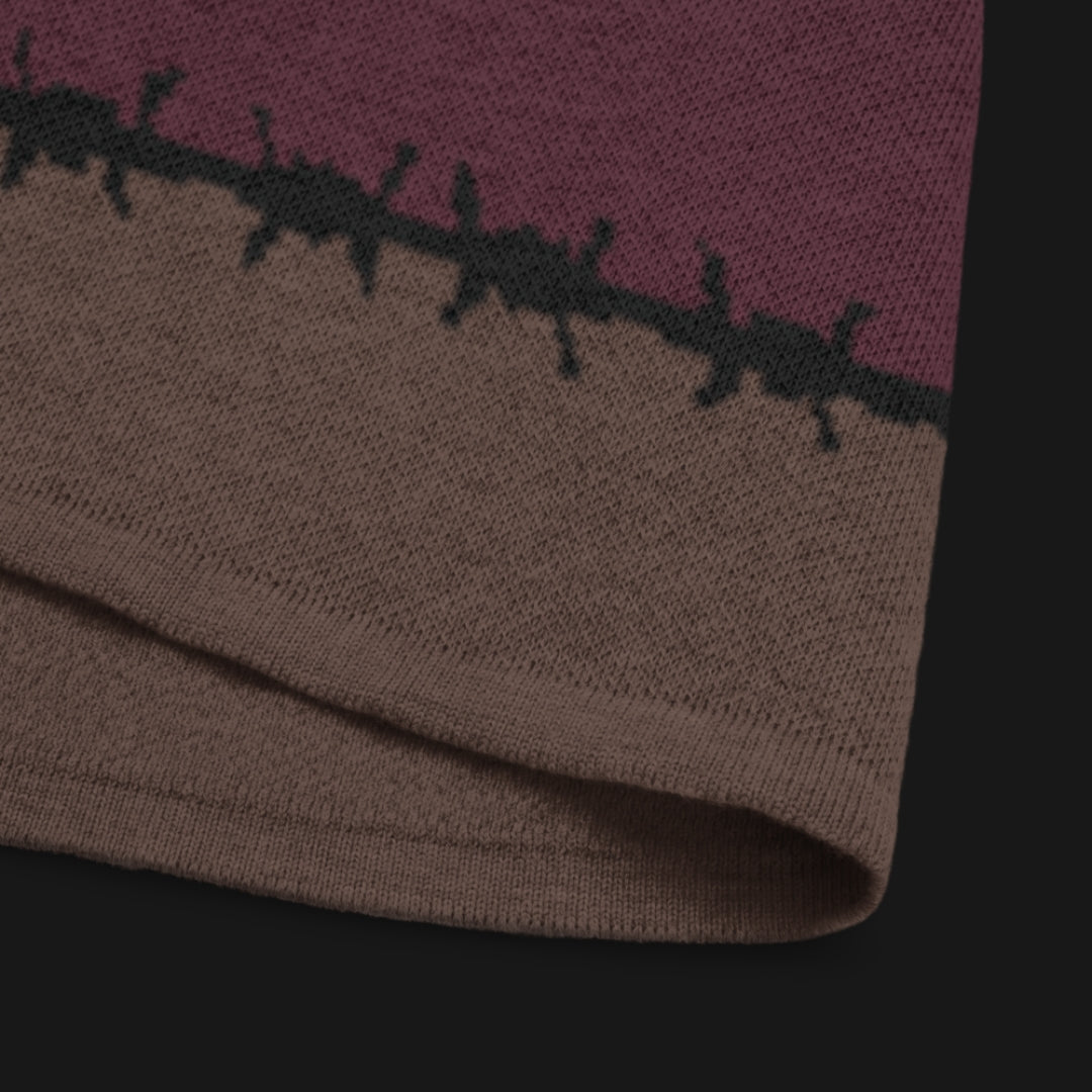 A jacquard knitted tee in dark moody shades, featuring stripes and a large heart lined with barbed wire