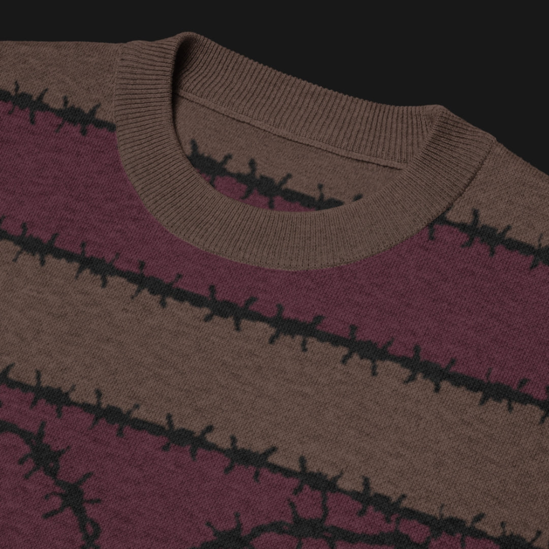 A jacquard knitted tee in dark moody shades, featuring stripes and a large heart lined with barbed wire