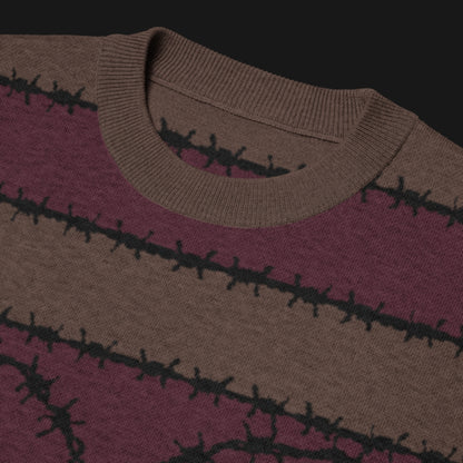 A jacquard knitted tee in dark moody shades, featuring stripes and a large heart lined with barbed wire