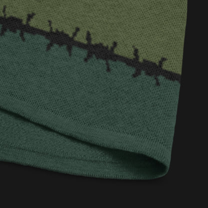 A jacquard knitted tee in dark moody shades, featuring stripes and a large heart lined with barbed wire