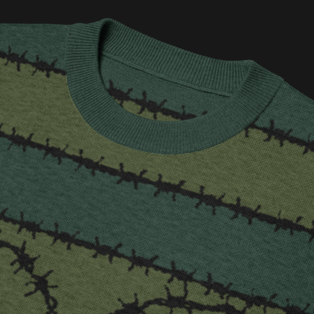 A jacquard knitted tee in dark moody shades, featuring stripes and a large heart lined with barbed wire
