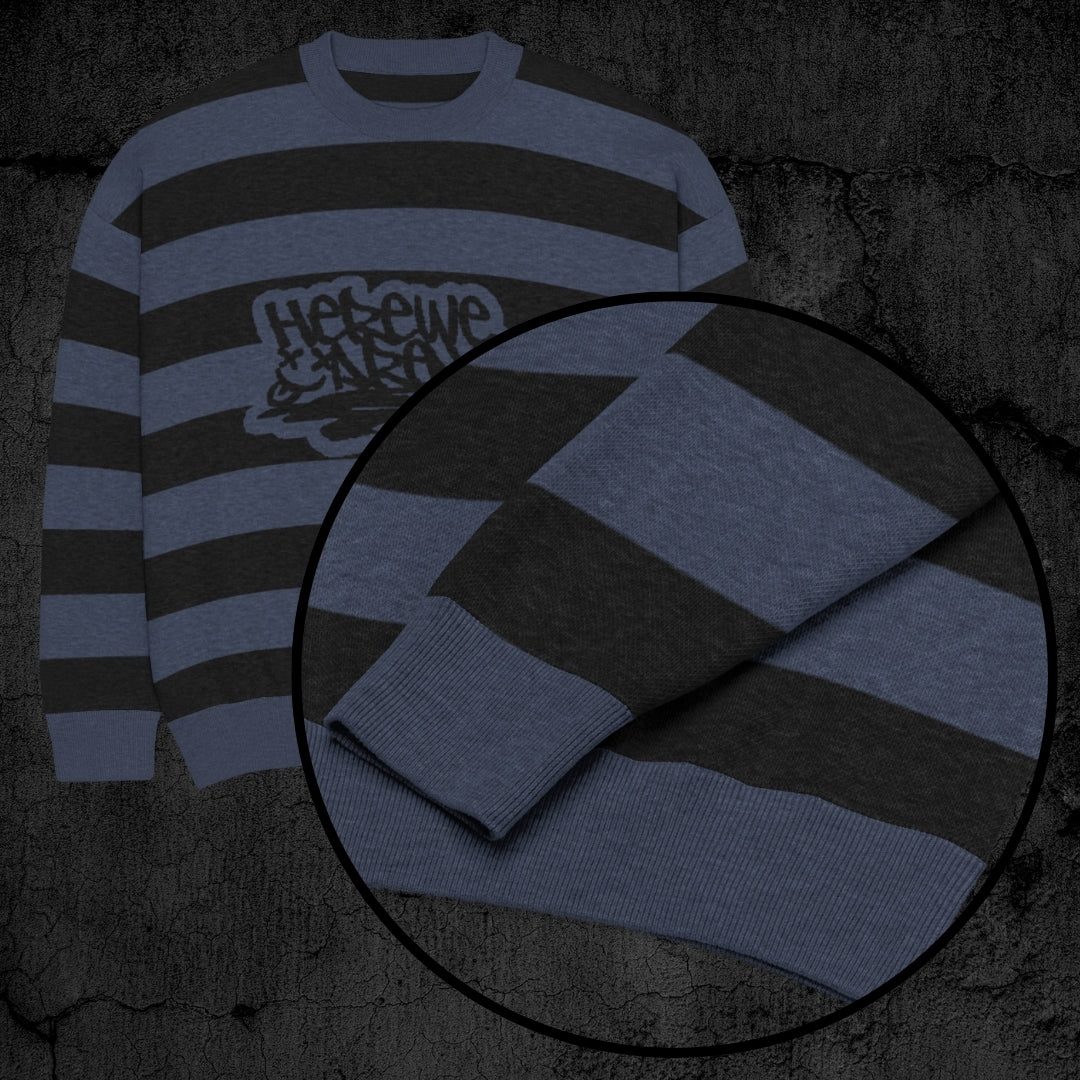 Black and blue grunge striped knitted sweater with a text "here we are now" in graffiti tag style, on a dark textured background