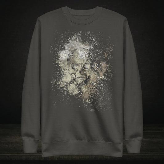 A cotton heritage M2480 sweatshirt with a subtle skull graphic surrounded and overlaid with paint splatter in camouflage colors on vintage black
