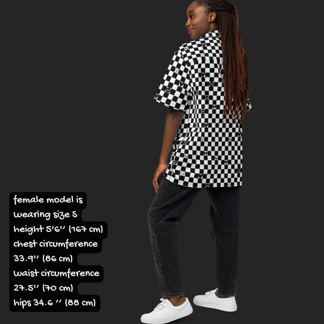 Person wearing a black and white checkered button up shirt with emo symbols