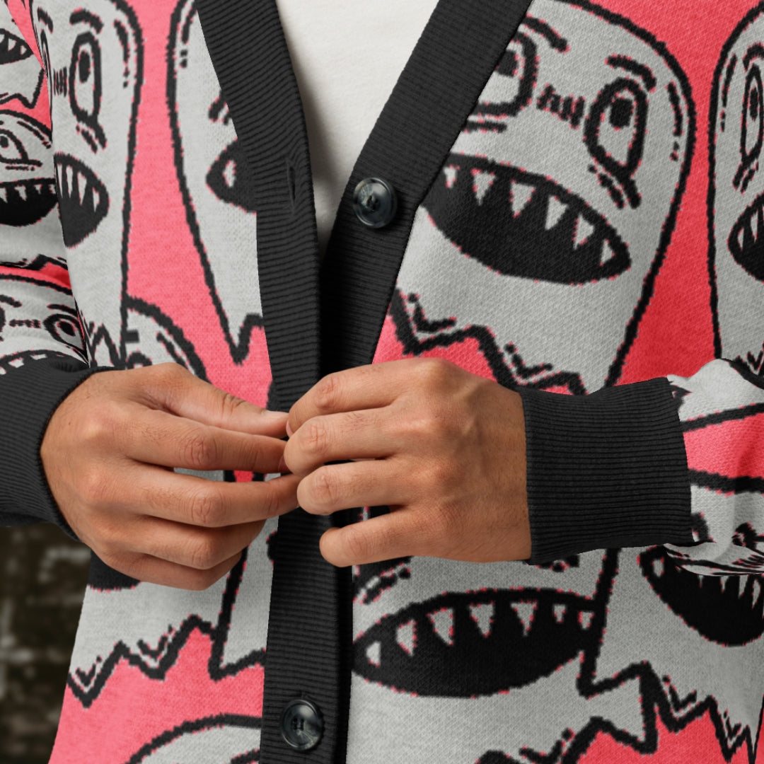 A woman wearing a hot pink knitted cardigan with large grey grinning goblins.