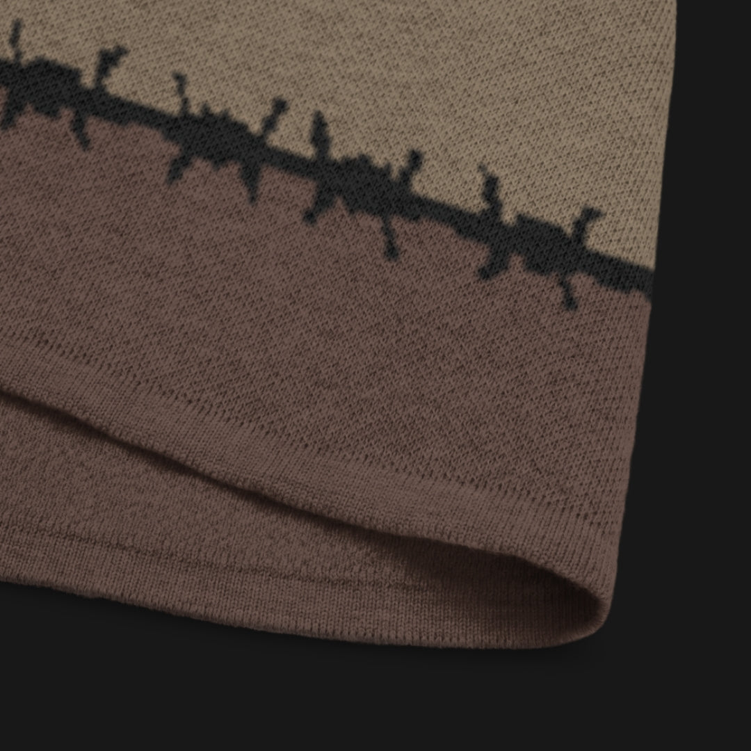 A jacquard knitted tee in dark moody shades, featuring stripes and a large heart lined with barbed wire