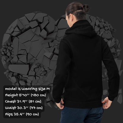 Person wearing a black hoodie with a pink checkered and distressed heart design against a dark background