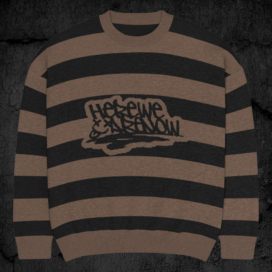 Black and brown grunge striped knitted sweater with a text "here we are now" in graffiti tag style, on a dark textured background