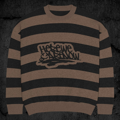 Black and brown grunge striped knitted sweater with a text "here we are now" in graffiti tag style, on a dark textured background