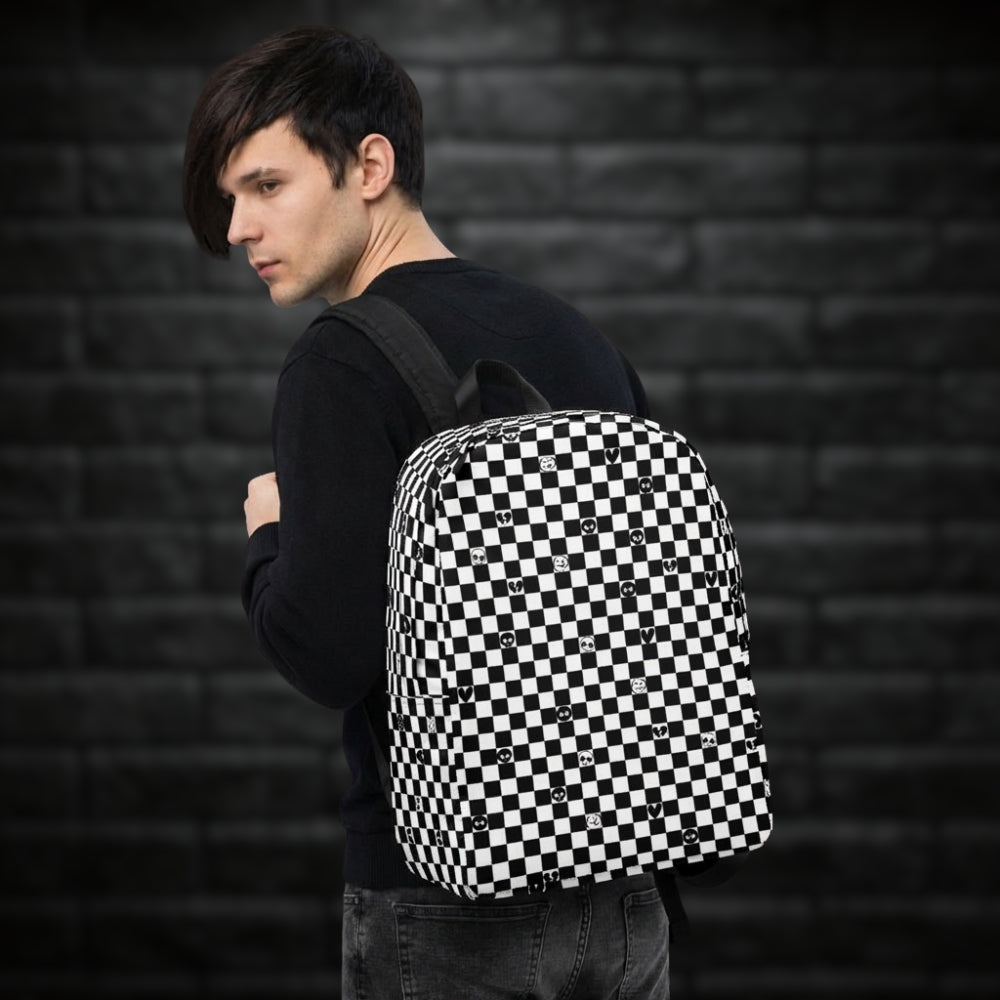 Man carrying a backpack with black and white checkers, and with emo symbols in some of the white squares 