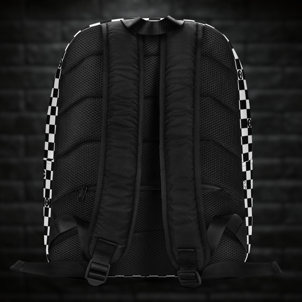 A backpack with black and white checkers, and with emo symbols in some of the white squares 