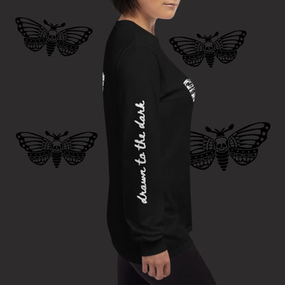 a woman wearing a black long sleeve tee with moth girl print in front and back and text on sleeves
