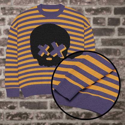 A violet mustard striped knitted sweater with a x-eye skull design against a brick wall
