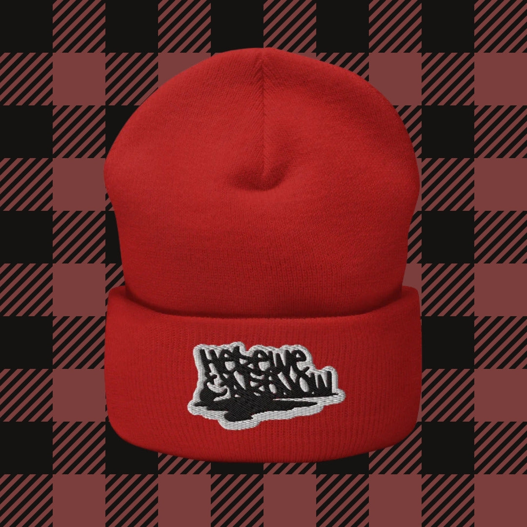 a beanie embroidered with "here we are now" in graffiti tag style