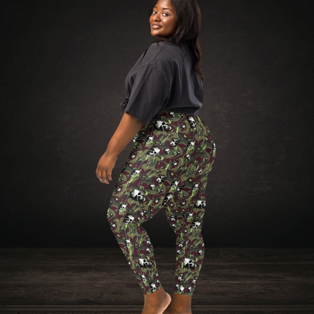 Person wearing leggings with burgundy and green camo splatter skull pattern