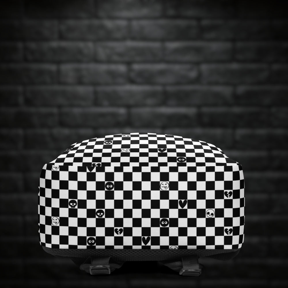 A backpack with black and white checkers, and with emo symbols in some of the white squares 