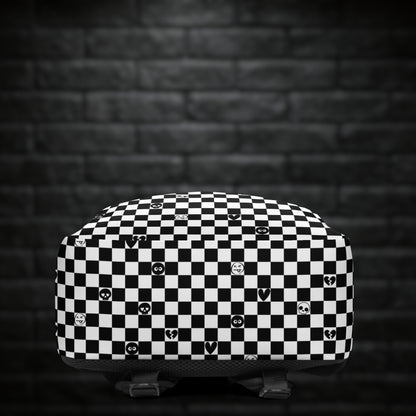 A backpack with black and white checkers, and with emo symbols in some of the white squares 