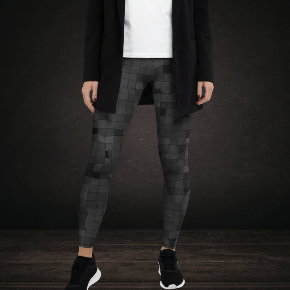 Person wearing leggings with an irregular distorted mosaic pattern in grey shades
