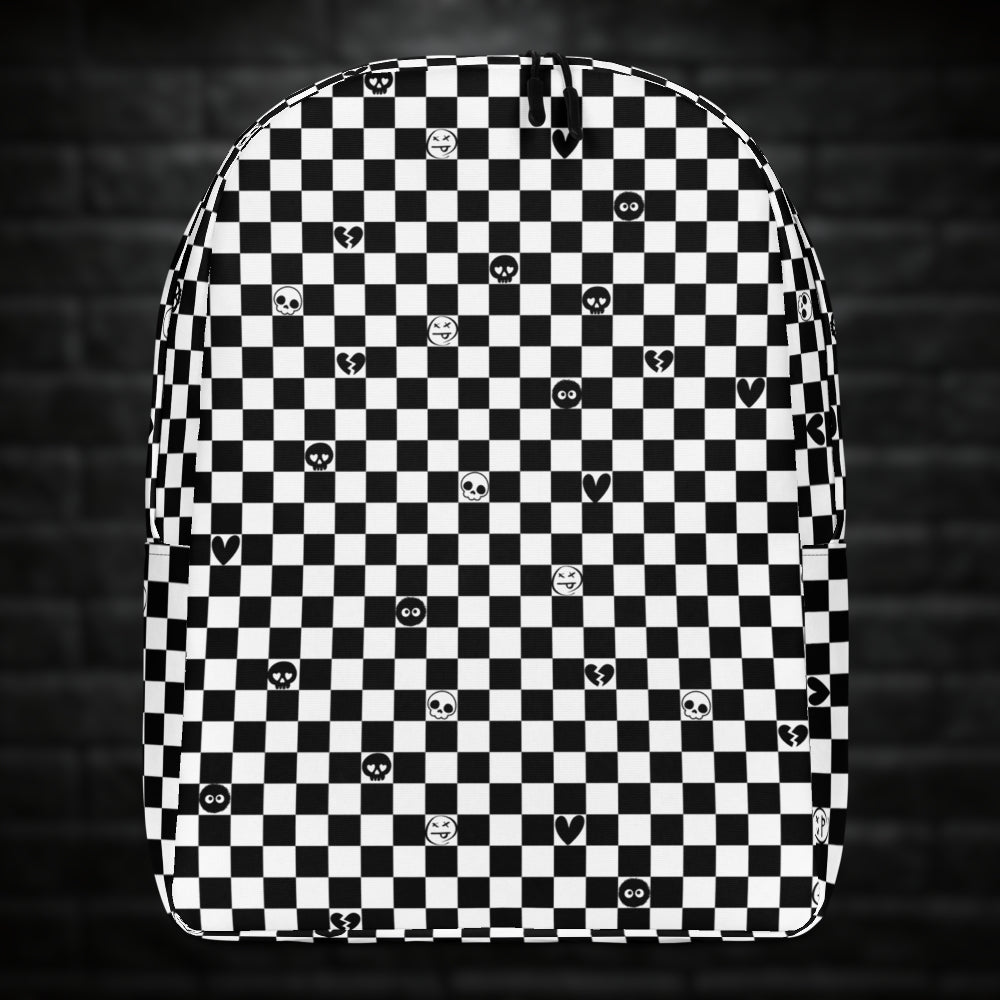 A backpack with black and white checkers, and with emo symbols in some of the white squares 