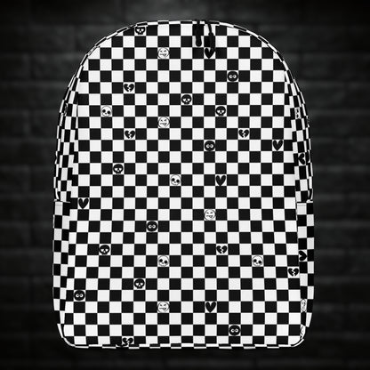 A backpack with black and white checkers, and with emo symbols in some of the white squares 