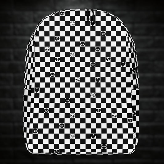 A backpack with black and white checkers, and with emo symbols in some of the white squares 