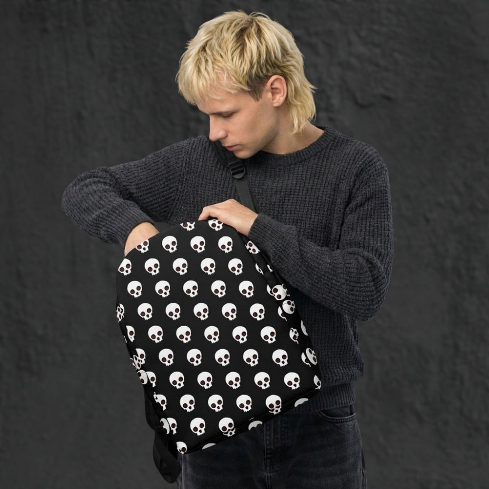 Person holding a black backpack with a cool skull pattern