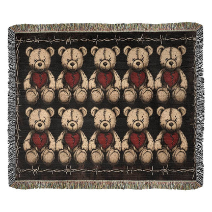 a woven blanket with x-eyed teddy bears on a dark background and surrounded by a frame of barbed wire