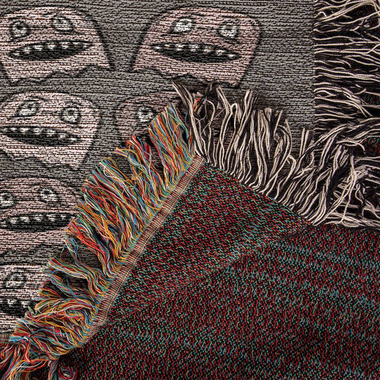 a woven blanket with a purplish grey and pink goblin pattern
