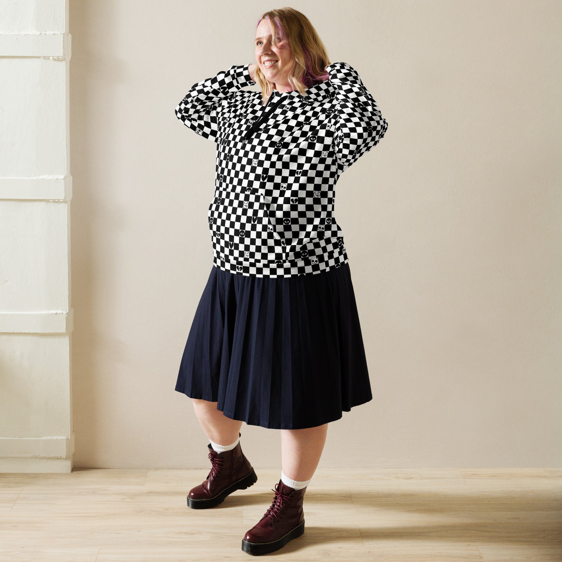 woman with a skirt and boots wearing a black and white checkered hoodie with emo symbols on some square