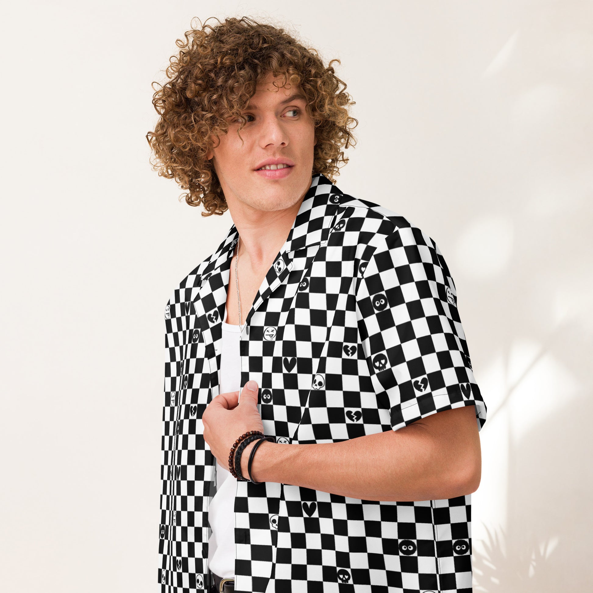 man wearing a black and white checkered button up shirt wit emo symbols