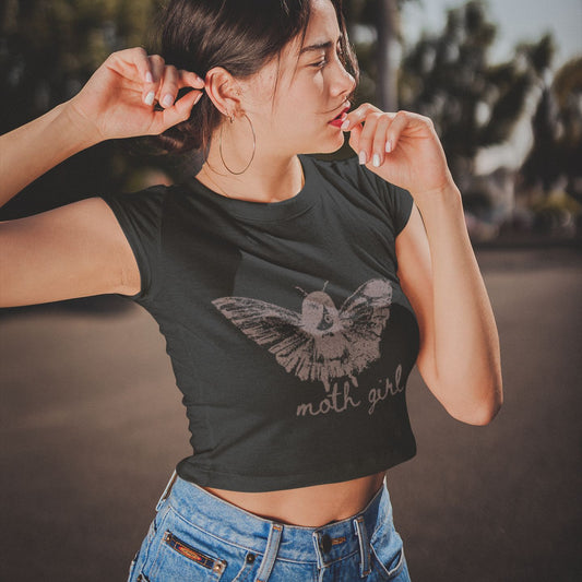 Woman wearing a black cropped t-shirt with a moth girl design and 'moth girl' text