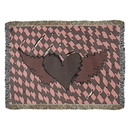a woven blanket with a deep red heart with wings on a distorted checkered pattern