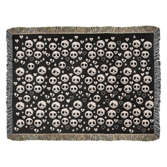 a woven blanket with a pattern of stitch mouthed emo ghouls and broken hearts on a dark background