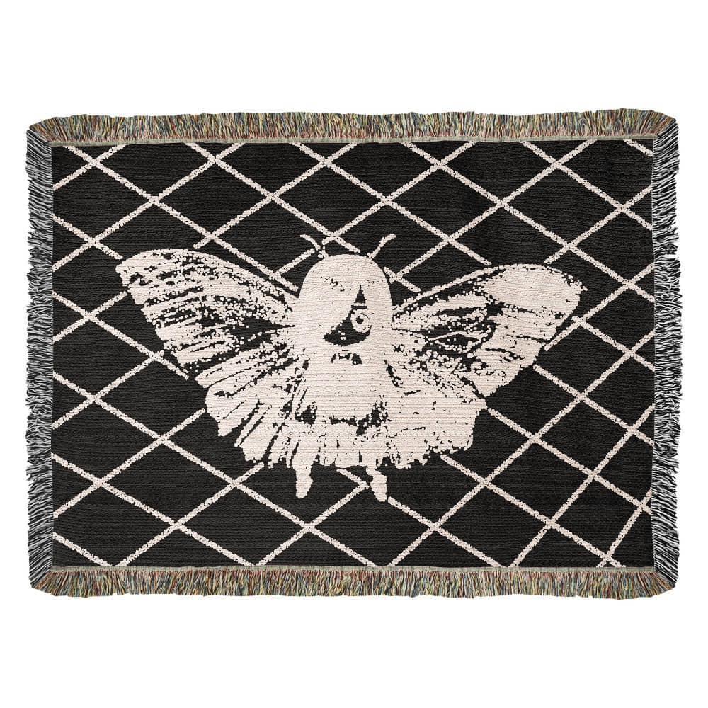 a woven blanket featuring a moth girl, wings spread on a background of a lattice grid