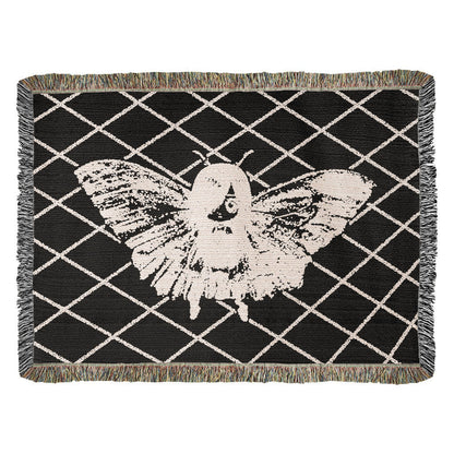 a woven blanket featuring a moth girl, wings spread on a background of a lattice grid