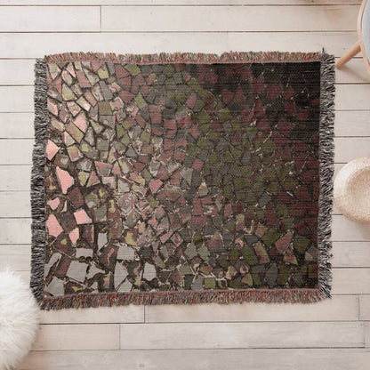 A woven blanket with deep red, black and lighter color shattered mosaic image