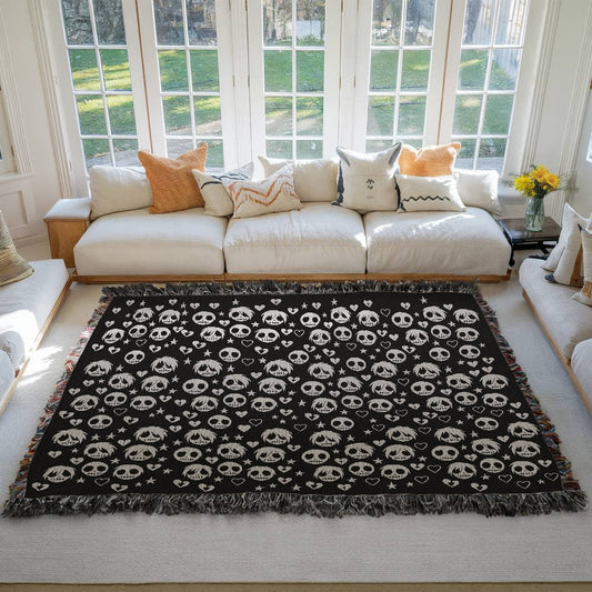 a woven blanket with a pattern of stitch mouthed emo ghouls and broken hearts on a dark background