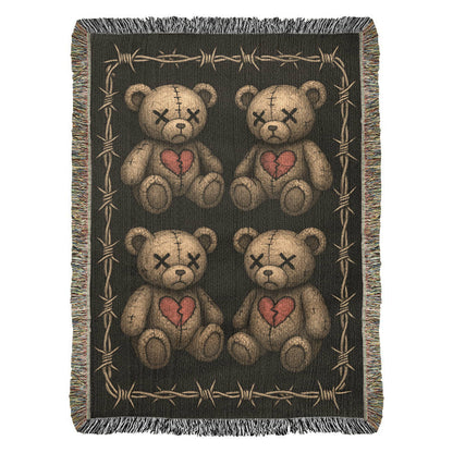 a woven blanket with x-eyed teddy bears on a dark background and surrounded by a frame of barbed wire