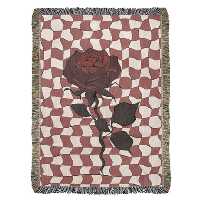 a woven blanket featuring distorted checkerboard patterns and a deep red soulful rose