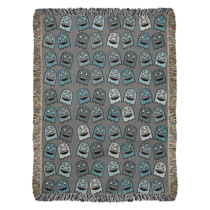 A woven blanket with grinning blue shade goblins on a grey background