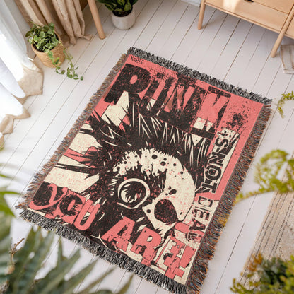 a woven blanket with a punk collage in pink and black, with text and a mohawk skull