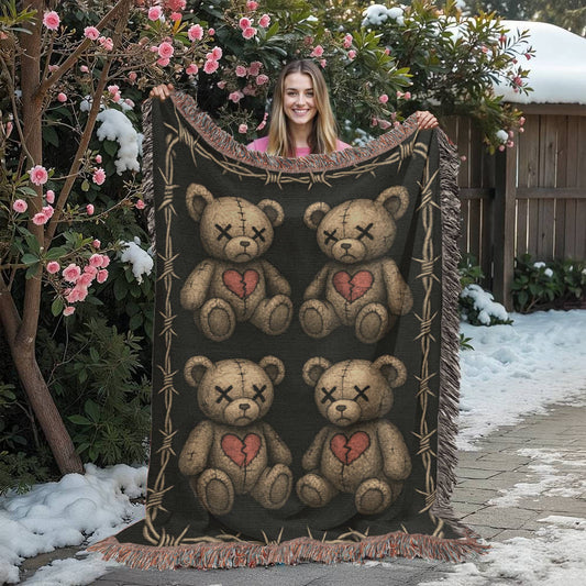 a woven blanket with x-eyed teddy bears on a dark background and surrounded by a frame of barbed wire