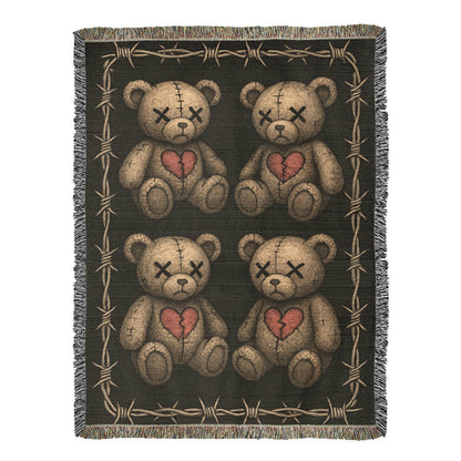 a woven blanket with x-eyed teddy bears on a dark background and surrounded by a frame of barbed wire