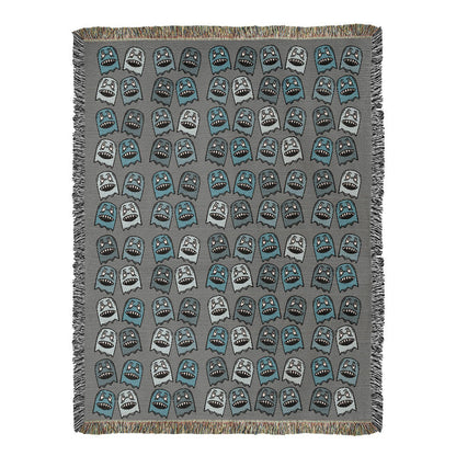 A woven blanket with grinning blue shade goblins on a grey background