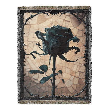 a woven blanket with a black wilted rose and shattered beige background, surrounded by a frame of thorns