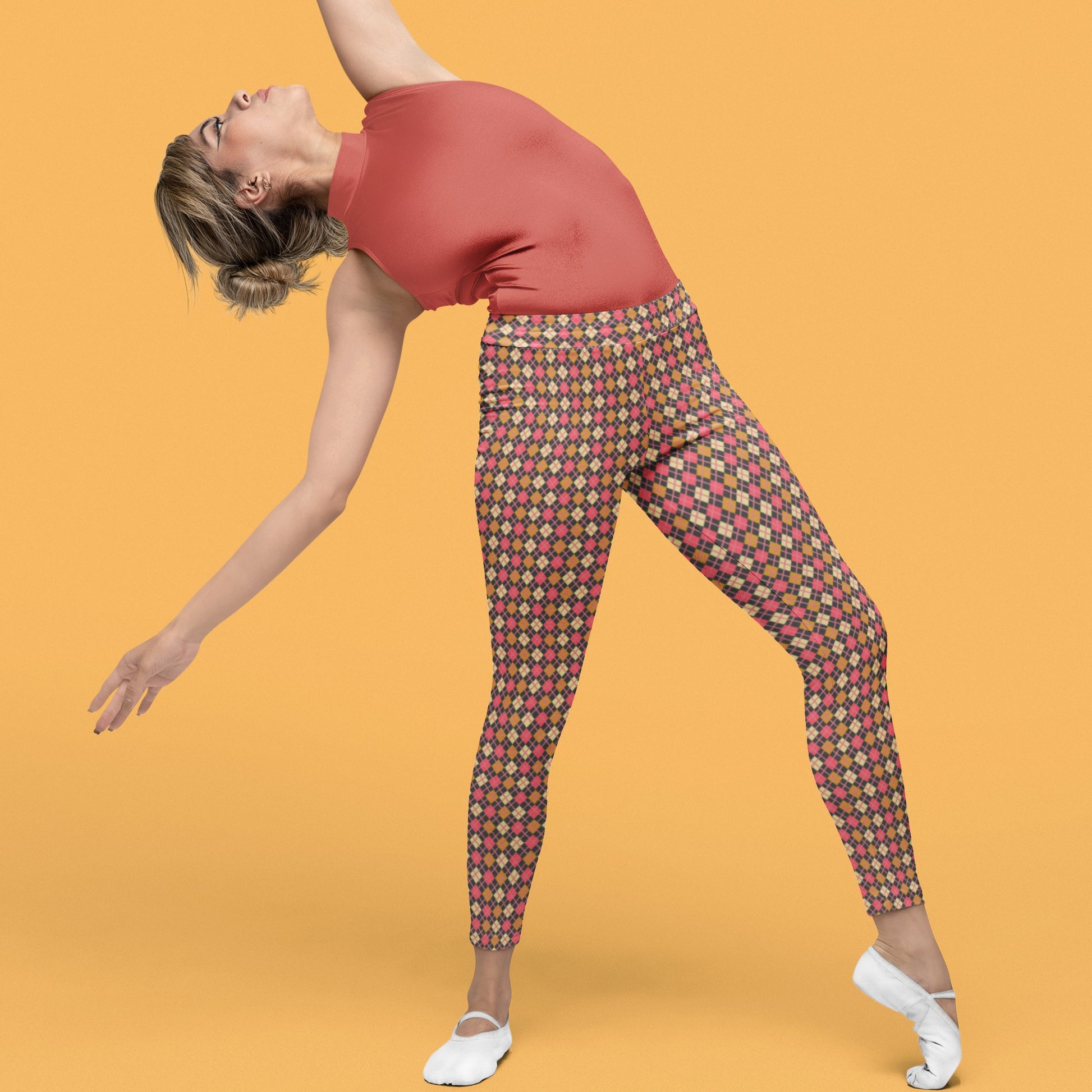 woman wearing leggings with diamond argyle pattern with charcoal base and pink accent