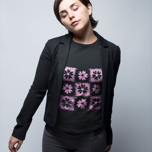 Person wearing a black blazer over a black t-shirt with emo vibe distressed pink floral pattern grid