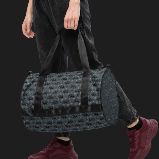 Person carrying a duffel gym bag with an emo armadillo pattern with broken hearts and storm clouds