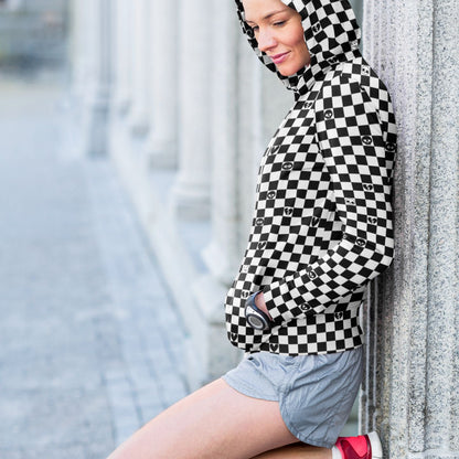woman wearing a black and white checkered hoodie with emo symbols on some squares